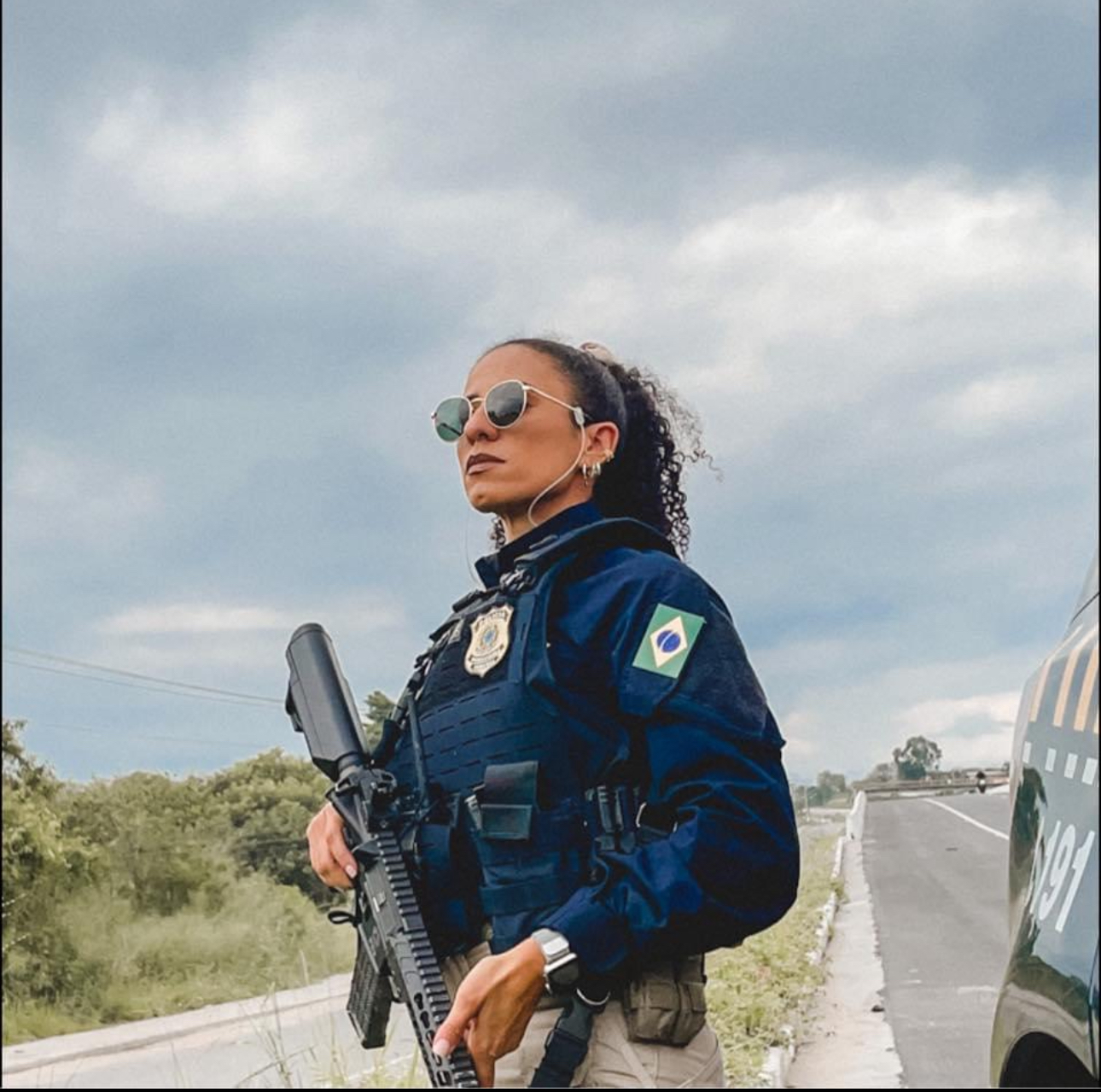 Adriana Karkow ao lado de viatura PRF